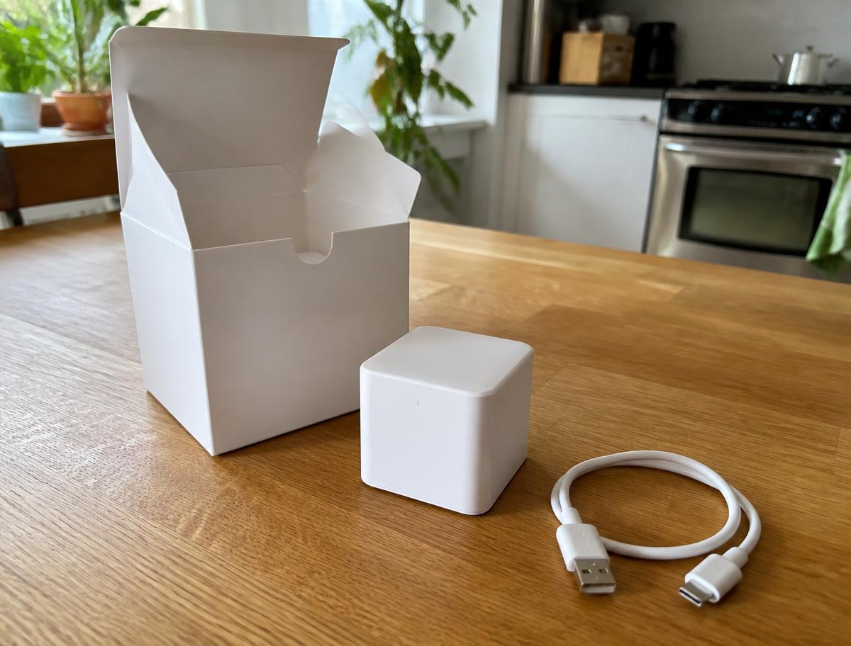 Il dispositivo HomeNETIX appena estratto dalla confezione, accanto al cavo USB, su un tavolo da cucina